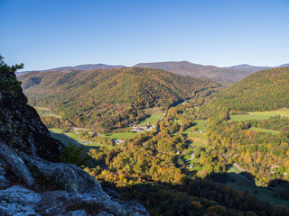 View from Seneca Rocks over the mountains in fall colors, blue sky and houses below in West...