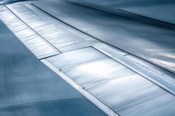 Close-up of an airplane wing showcasing sleek metallic surfaces.