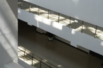 The quiet minimalist white multi-storey buiding during the day with bright light from the trasparent roof