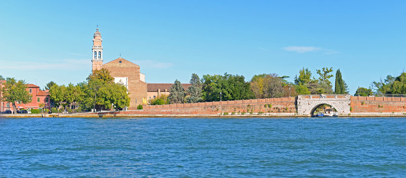 Lido island with Saint Nicholas church on a bright summer day with blue lagoon and blue sky in Venice, Italy