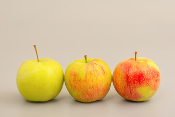 Three apples on a gray background.