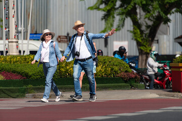Obraz premium An elderly couple walks around the street in the old city of Bangkok, Thailand.