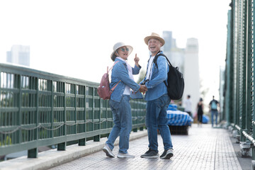 Elderly couples travel on the old iron bridge (Phra Phutthayotfa Bridge) in Bangkok, Thailand
