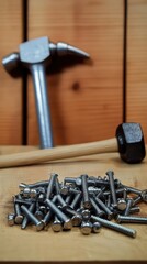 A collection of metal screws with hammers in the background.