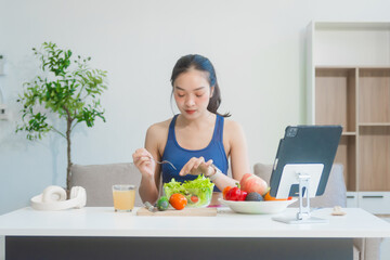 A young Asian housewife enjoys a healthy lifestyle at home, balancing fitness routines with...