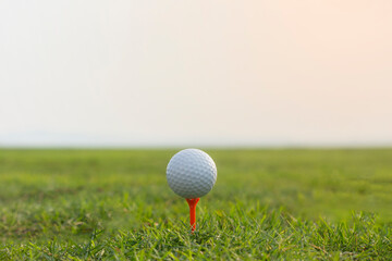 golf ball on tee in a beautiful golf course with morning sunshine.