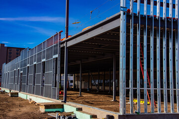Metal studs along exterior wall of steel framed office building under construction.