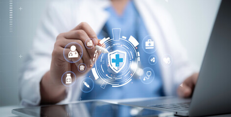 Healthcare professional interacts with a glowing shield icon on a laptop, representing secure and...