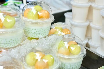 Tapioca pudding with coconut cream and fresh melon balls (honeydew, rock melon)  for sale at Soi 20, an open street market selling fresh produce and street food in Silom - Bang Rak, Bangkok