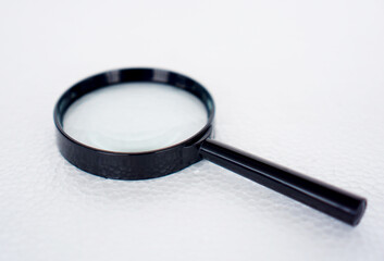 magnifying glass with 75mm diameter with 3x magnification, black plastic handle isolated on white...