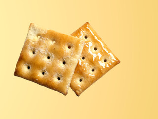 two biscuits crackers stacked on the side isolated on light brown background