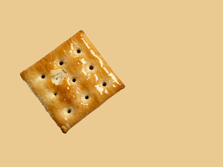 a cracker biscuit placed separatey on brown background in flat lay shot