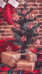 A trendy, minimalist Christmas setup featuring a monochromatic Christmas tree decorated with gold and silver ornaments
