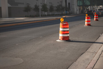 Orange construction barrels used for traffic control and roadwork zones on an urban street in Las...