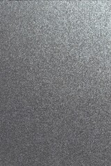 a close up of a silver metal surface with a black background