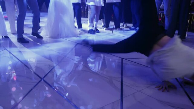 Breakdancer captivating wedding guests with impressive moves on the dance floor during a lively celebration, creating an energetic atmosphere filled with joy and excitement