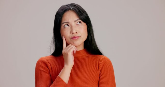 Thinking, idea and woman in studio with question, doubt or decision for career development. Choice, unsure and Japanese female person with solution, brainstorming or planning by gray background.