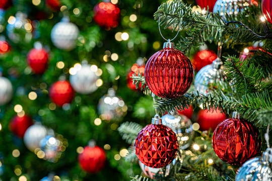 Close-up of Fully Decorated Christmas tree with red and White balls and bokeh in the background. copy space for holiday design. - Powered by Adobe