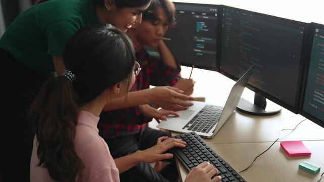 Slow motion back end software developer engineer for computer programming working together on debugging writing computing code, solving complex algorithms display on monitor in office. Burgeoning