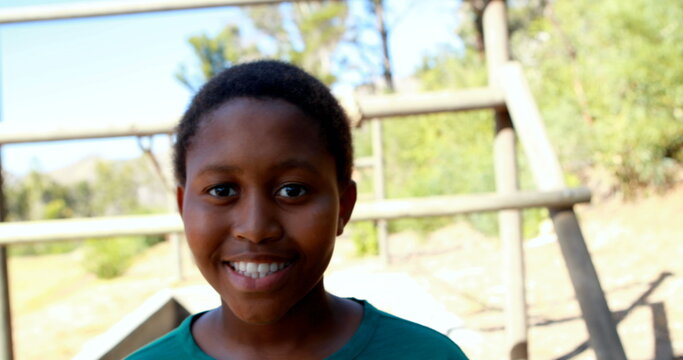 Portrait of happy boy standing in boot camp during obstacle course