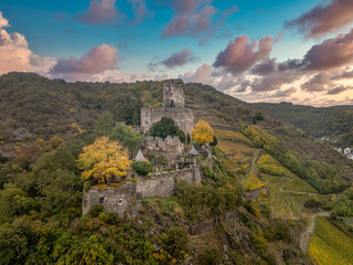 Aerial view of Gutenfels medieval knight castle above the Rhine river in Germany with dramatic colorful sunset sky