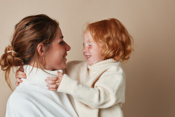 Happy mother holding cute smiling daughter, family love and bonding, joyful parenting moments, motherhood and childhood happiness