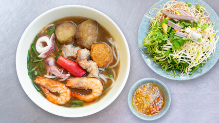 Bun Mam noodles soup. Popular Vietnam seafood noodles soup - Bun Mam noodles. Bowl of delicious Vietnamese seafood noodles soup served with vegetables	