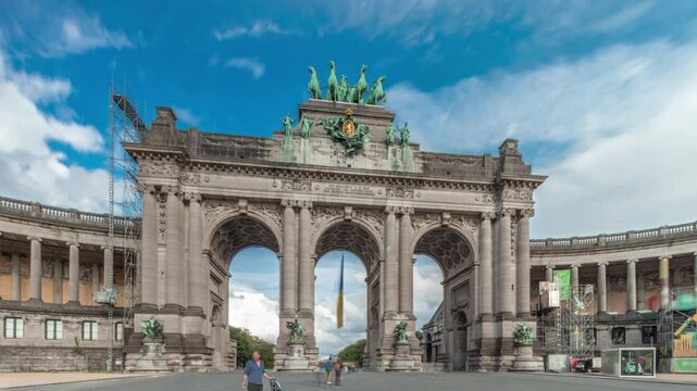 Hyperlapse of the Cinquantenaire Arcade in Jubelpark, Brussels, Belgium. The memorial triumphal arch stands tall under dramatic clouds timelapse, symbolizing Belgian history and independence.