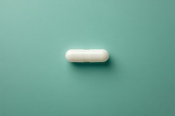 Single white capsule on teal background. Illustrates medicine, health, or pharmacy concepts.