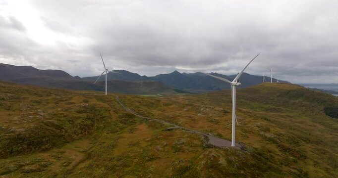 Spinning blades of wind turbines on mountains, Sortland, Norway. Drone view
