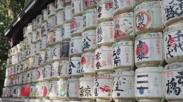 Slow-motion video of beautifully decorated sake barrels at Meiji Jingu Shrine during the daytime in Yoyogi Park in Tokyo.