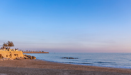 Beach with a rocky shoreline and a clear blue sky