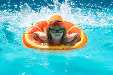 Boy kid swimming and playing in a pool. Child playing in swim pool. Summer vacation concept. Summer kids portrait.