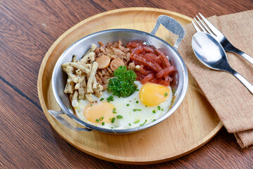 A photo of a plate of food that has two eggs, pork, and vegetables.