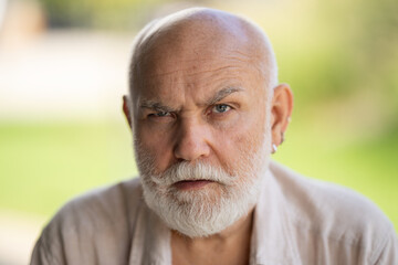 Middle-aged senior grandfather close up portrait. Grey hair white beard old man. Senior serious. Face of bearded senior age man. Closeup emotional portrait of an old mature senior man with grey beard.