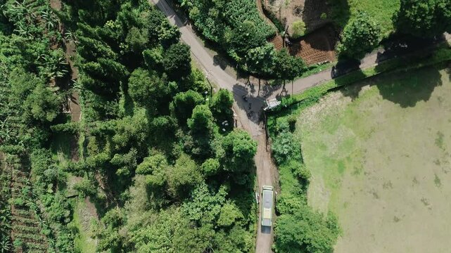 A green mountainous area with a villa, as several buses prepare to leave the premises. Perfect for travel, tourism, or real estate projects showcasing scenic landscapes and group activities