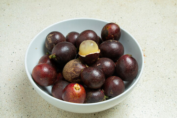 View of a white bowl containing matoa fruit (Pometia pinnata) which can be called betel nut