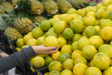 Female hand holding an orange in a supermarket.