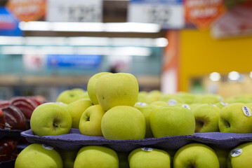 Group of yellow apples in a supermarket.