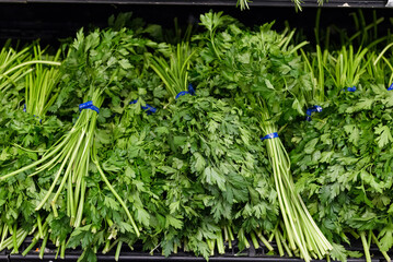 Bunches of parsley on a supermarket shelf.