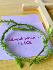 Second Advent Sunday Concept - advent week 2 peace text on purple paper background. Stock photo.