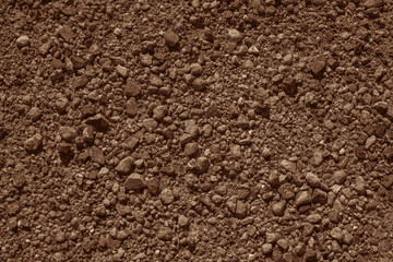 Full frame of small size multi colored rocks ground surface with no vegetation for backdrop. Deserted rocky textured surface resemmblig Mars. Mocha brown color