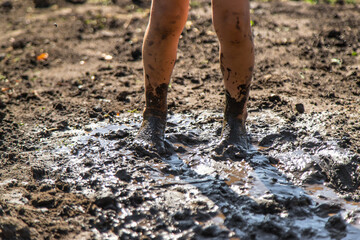 Child playing in mud. Selective focus.