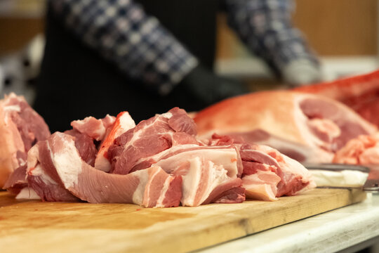 Freshly cut pork slices on a wooden table during butchering