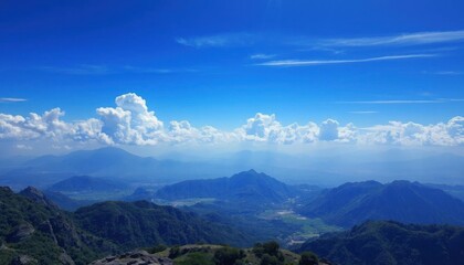 Fototapeta premium a view of a mountain range with a valley below and a blue sky