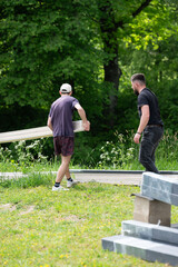 Men carry boards to assemble a gazebo in a lavender field.
