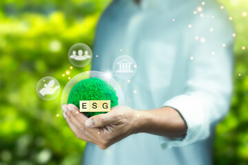 Man holding green globe on nature background with icon Environmental, renewable, sustainable...