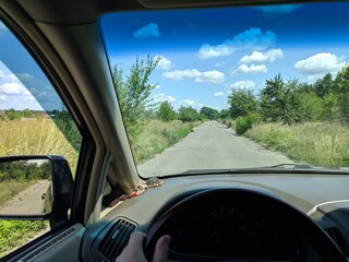 inside the car. driver behind the wheel. drive a car. journey. bad roads. by car . steering wheel and dashboard. wheels and engine.