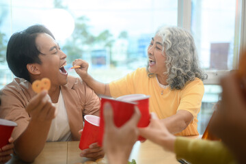 Happy corporate coworkers enjoying celebration party with snacks and drinks