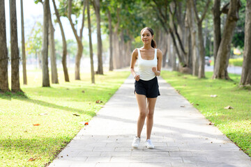 Portrait of beautiful young African American woman running on path in park